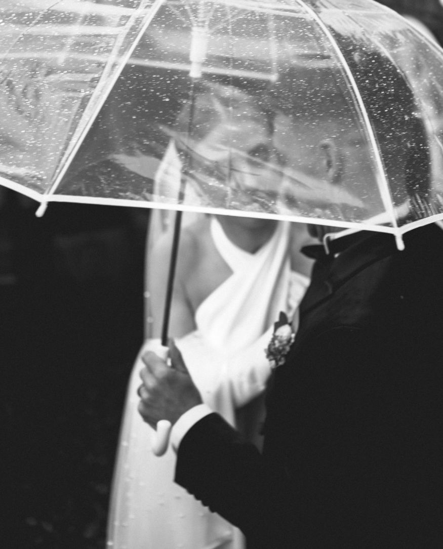 Couple sharing a clear umbrella in the rain